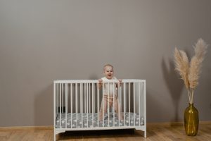Baby standing in crib - Cribs; The Safety Edition