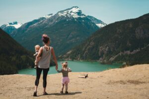 woman walking with kids in front of mountain