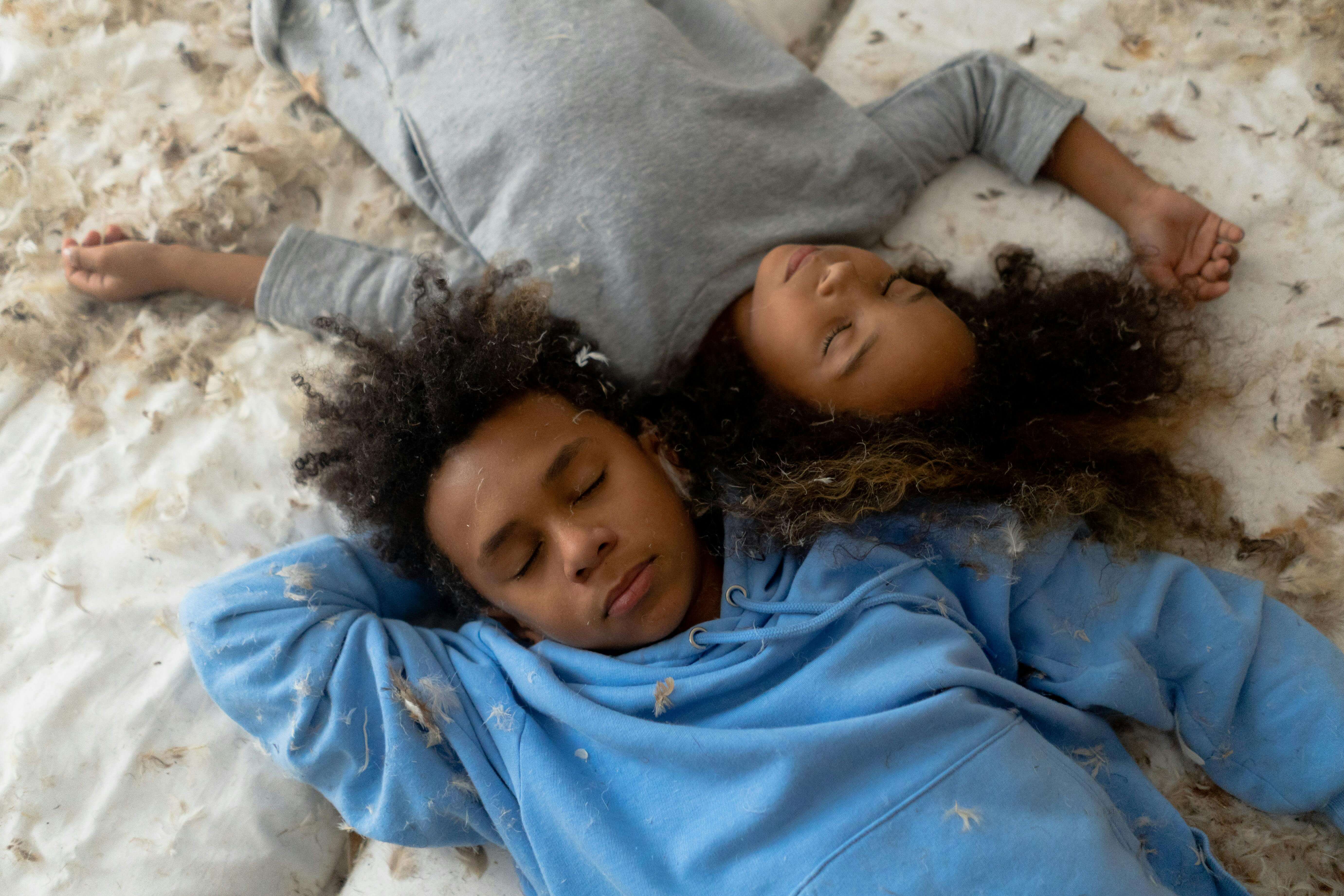 two children laying head to head asleep