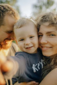 Mother and father holding a baby and smiling