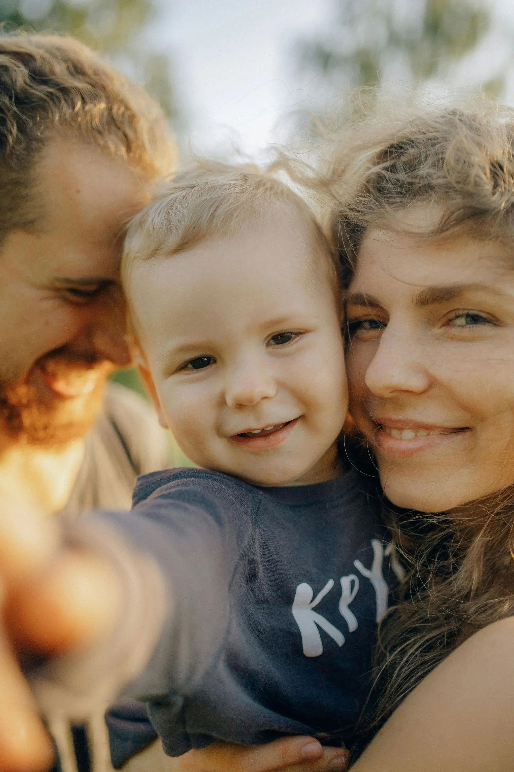 Mother and father holding a baby and smiling