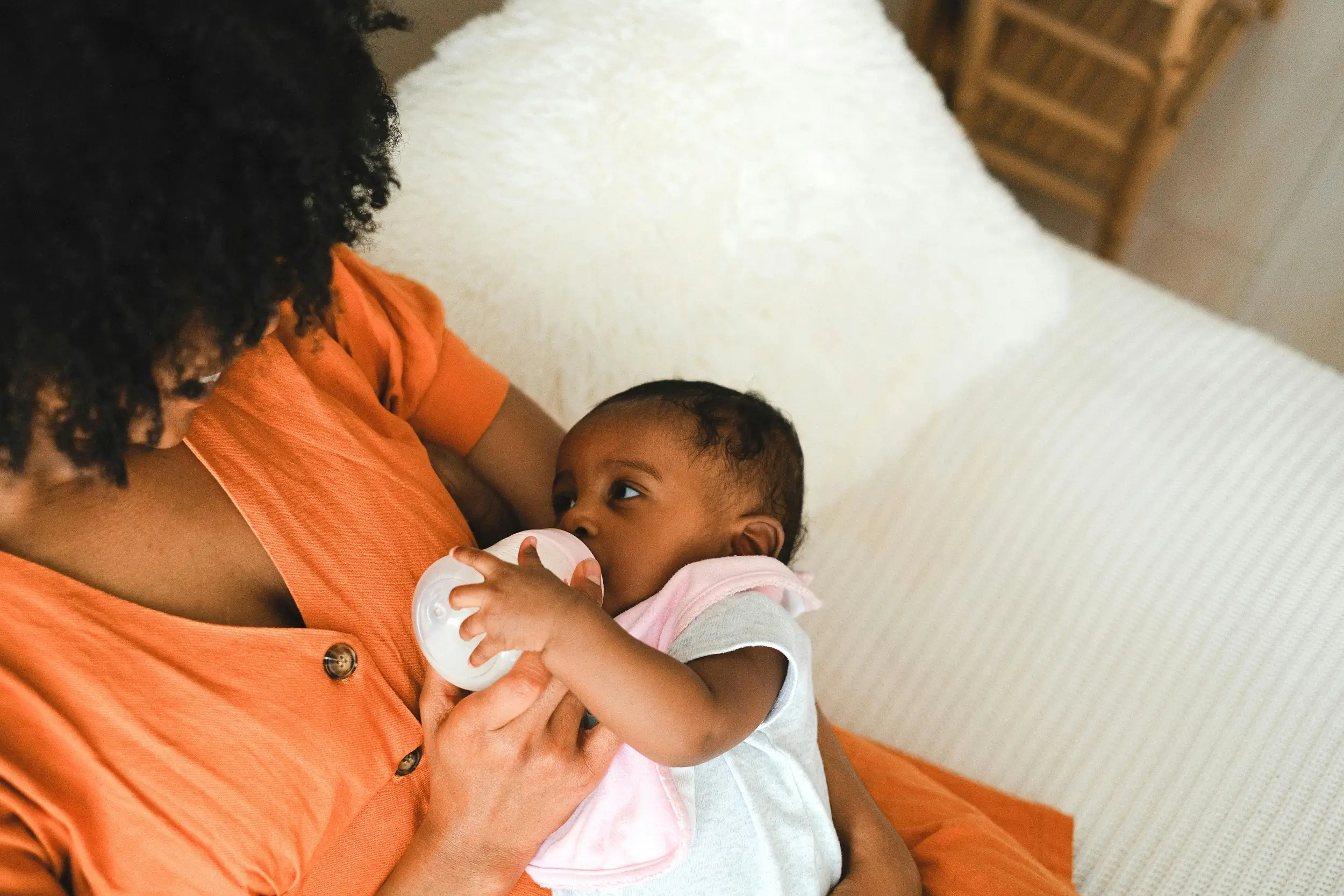 Mother holding baby drinking milk from a bottle